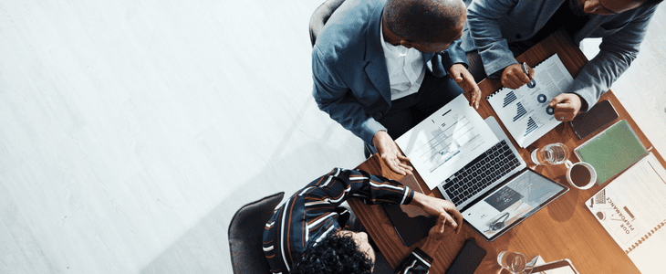 An aerial view of a team sitting and discussing KPIs and buisness objectives